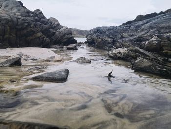 Rocks at sea against sky