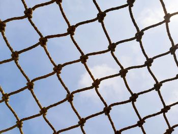 Football goal post netting against blue sky