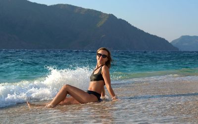 Full length portrait of young woman at beach