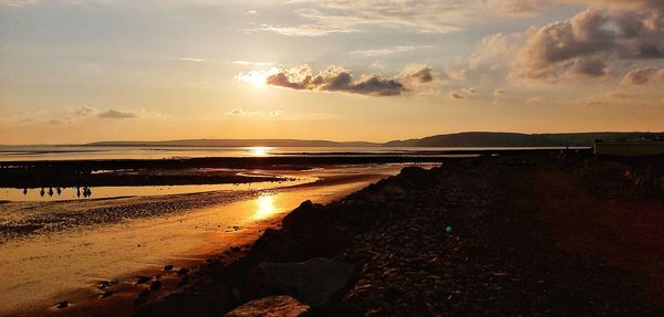 Scenic view of beach against sky during sunset