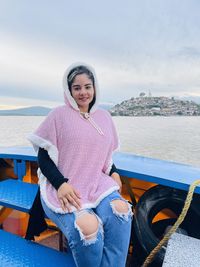 Portrait of young woman sitting at beach