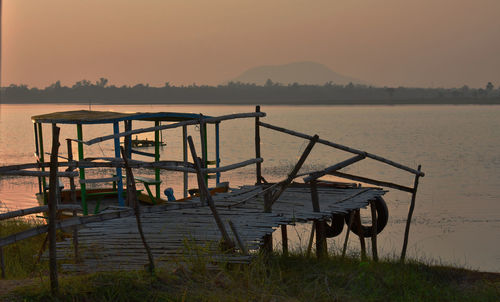 Lifeguard hut on land against sky during sunset