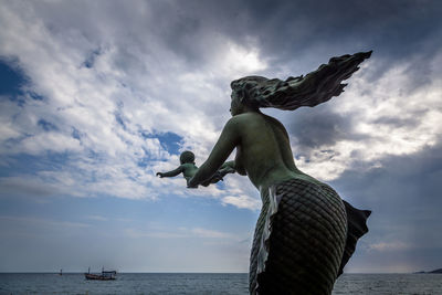 Low angle view of statue against cloudy sky