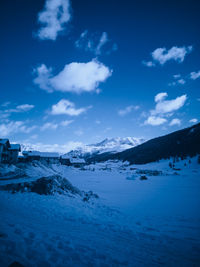 Scenic view of snow covered land against blue sky