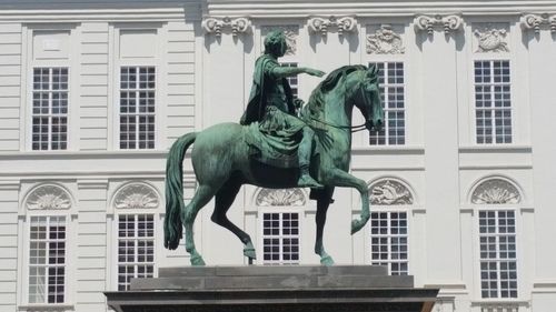 Statue of woman in front of building