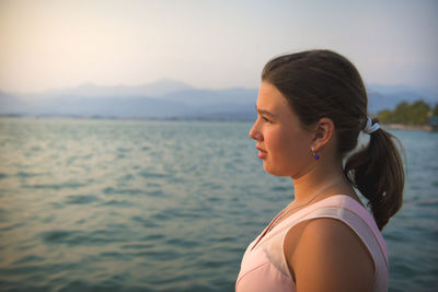 Side view of girl standing by sea