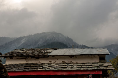 House roof of building and mountains against sky