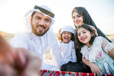 Portrait of happy family sitting at desert 