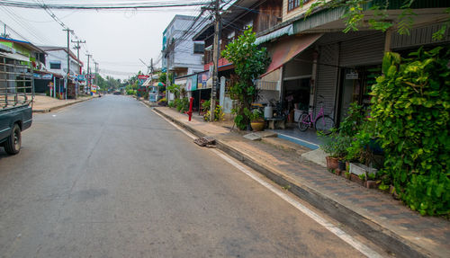 Empty road amidst buildings in city