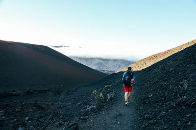 Male backpacker hiking in haleakala crater on maui, hawaii.