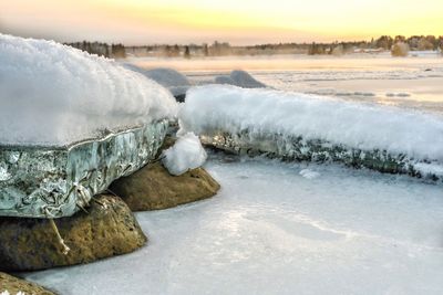 Snow covered landscape during sunset