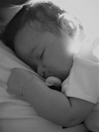 Close-up of baby sleeping in bed