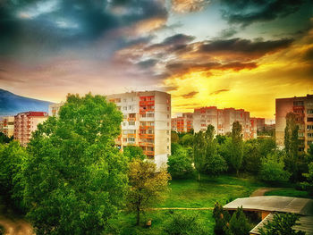 Buildings against cloudy sky at sunset