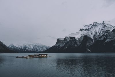 Scenic view of lake by snowcapped mountains against sky