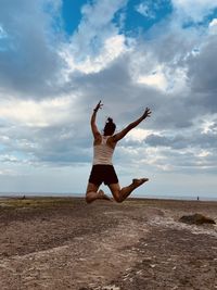 Full length of young woman doing yoga at beach