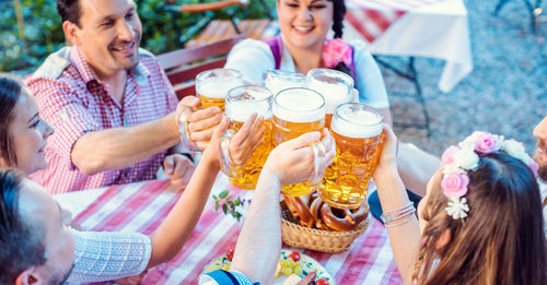 High angle view of people toasting drinks in glasses