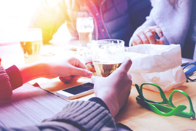 Midsection of woman holding drink on table