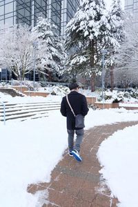 Rear view of woman standing in snow