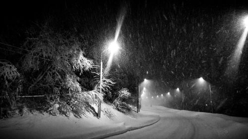 View of illuminated road at night during winter