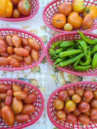 Above view of baskets of vegetables on table in vendor's booth at local farmer's market