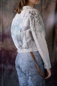 Rear view of woman standing against white wall