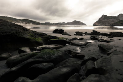 Rocks on beach against sky