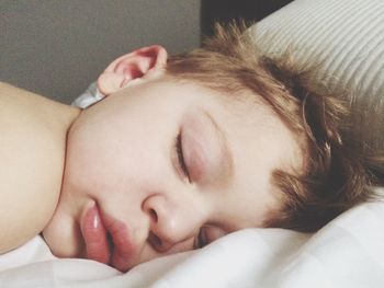 Close-up of boy sleeping on bed at home