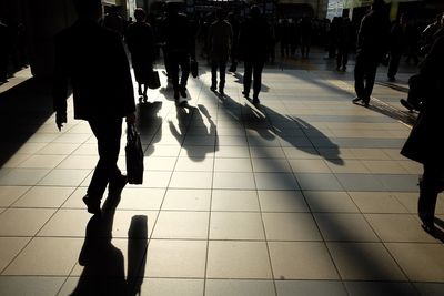 Low section of people walking on street in city