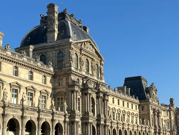 Low angle view of historical building against clear blue sky