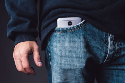 Midsection of man with mobile phone in pocket