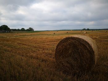 Hay bales on field against sky