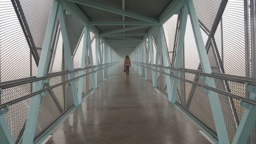 Rear view of woman walking on bridge