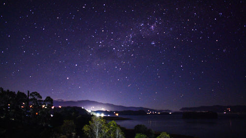 Scenic view of illuminated mountains against sky at night