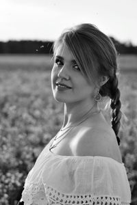 Portrait of smiling young woman standing on field