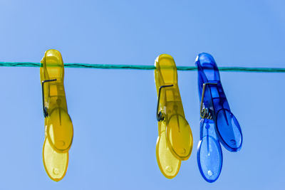 Close-up of yellow hanging over water against blue background