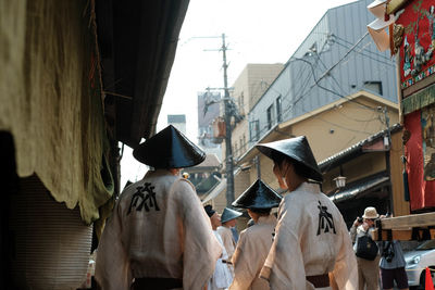 Rear view of people against buildings in city