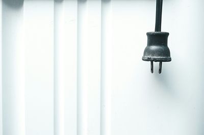 Close-up of lamp post against wall