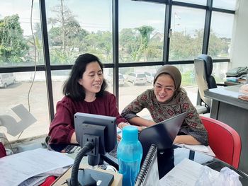 Two business women are meeting in the small office and look so happy