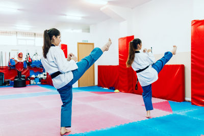 Rear view of people doing taekwondo