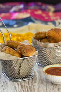 Close-up of fried chicken in containers with sauce on table