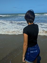 Rear view of woman looking at sea shore