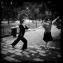 Full length of woman standing on footpath in park