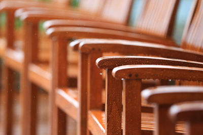 Close-up of empty wooden chair in the rain