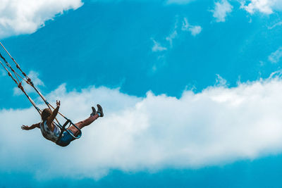 Low angle view of man paragliding against sky