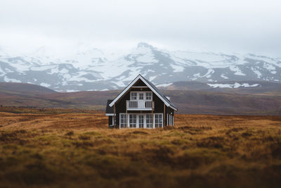 Built structure on snowcapped mountain against sky