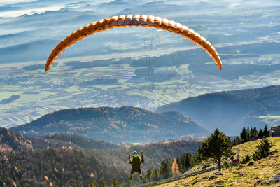 High angle view of person paragliding over mountains