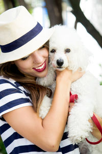 Young woman with dog against plants