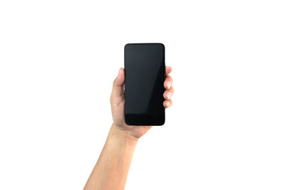 Close-up of hand holding smart phone against white background