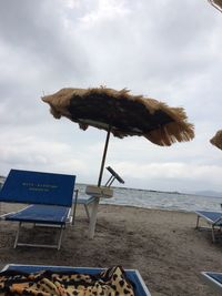 Traditional windmill on beach against sky