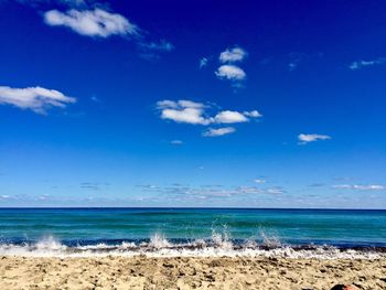 Scenic view of beach against blue sky